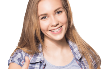 A person with long hair and braces smiles while giving a thumbs-up gesture. They are wearing a plaid shirt over a gray top.