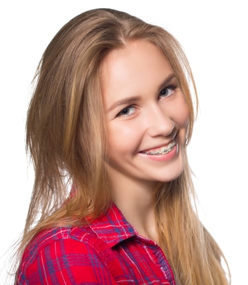 Young woman with long blonde hair wearing a red plaid shirt smiles and shows her braces.