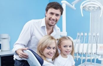Parents with their little daughter at a dentist office.