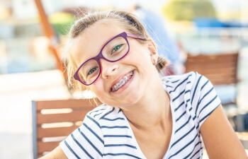 Cheerfully smiling preteen girl with orthodontic braces.