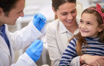 Caring mother assisting her daughter at a dental exam